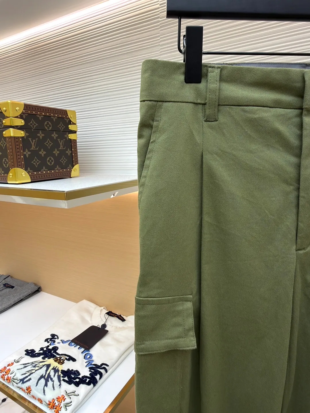 LOUIS VUITTON portrait embroidered work trousers ●Item number: 1681219-B65 ●Material: cotton twill fabric ●Technology: embroidery production ●Color: green ●Version: fitted version ●Weight: about 655 grams ●Size: 44-46-48-50 ●Description: The high cotton content ensures the fabric's excellent breathability, durability and classic workwear texture, while the twill weave gives it unique wear resistance and stiffness. The special fabric technology solves the pain points of tight and stiff traditional overalls; it provides greater freedom when moving, significantly improves wearing comfort and flexibility, and achieves a balance between function and comfort. For the embroidered portrait patch on the left, the portrait is digitally processed and converted into a line drawing blueprint that can be embroidered. A high-precision computer embroidery machine is used to perform multi-layer embroidery, and the outline, light and shade and texture details of the portrait are created by interweaving and superimposing embroidery threads of different colors. Tens of thousands of stitches and fine color transitions ensure clear lines and no unnecessary threads, making the portrait lifelike and three-dimensional. The design of the trousers combines retro workwear genes with modern deconstruction. The core lies in the neat pleat processing, which not only deconstructs the flat silhouette of the front, increases the three-dimensional sense and design level, but also visually optimizes the leg lines. Multiple flap pockets are classic workwear functional elements and the overall tough style. The overall wiring is straight and delicate, the fabric is comfortable and soft, and the color is consistent without color difference. It can be matched with the same style to create a fashionable look and control various occasions. Customized accessories, complete with three standards, same style for men and women!